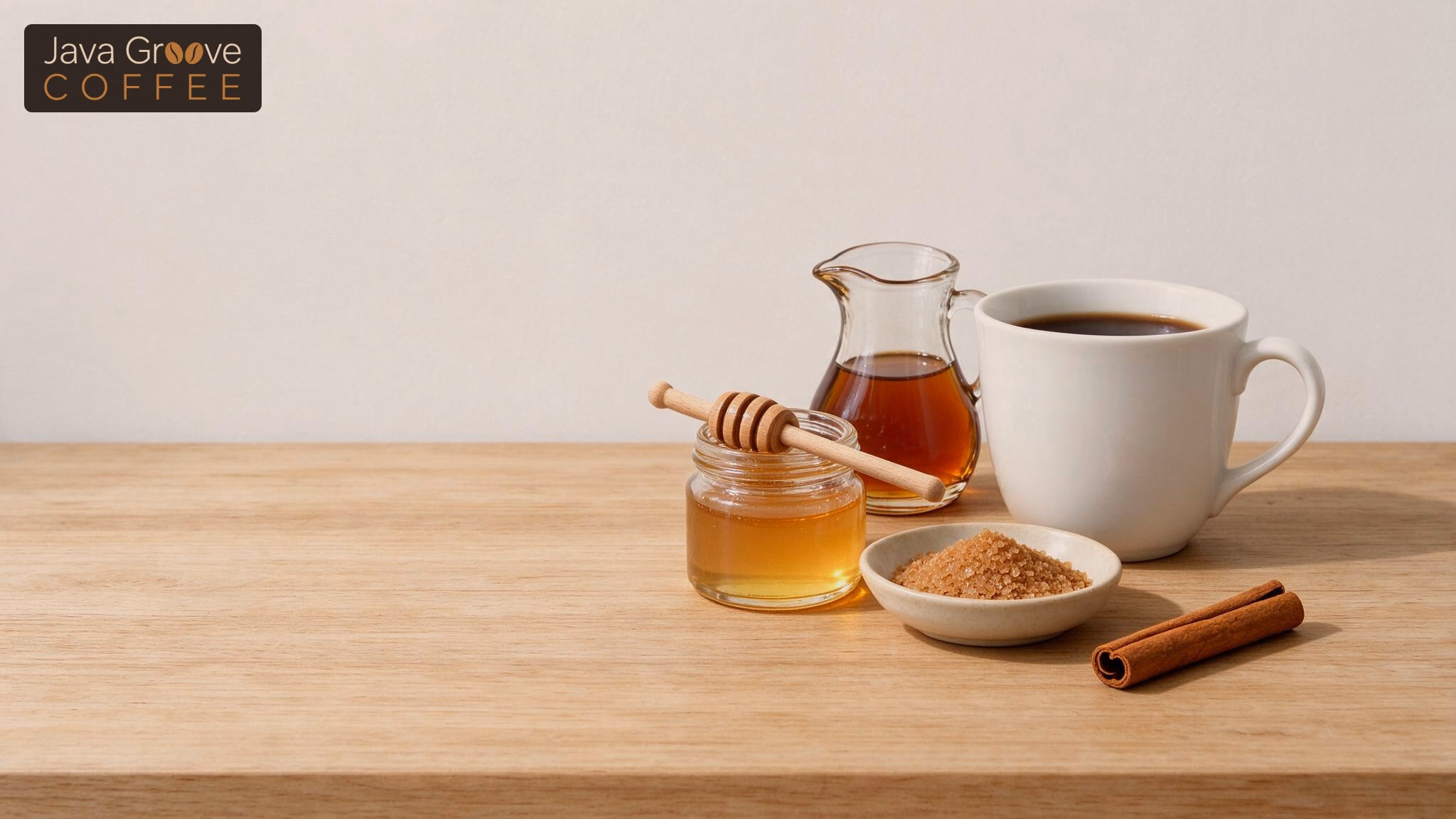 Sugar alternatives for coffee, honey, maple syrup, coconut sugar and cinnamon beside a mug